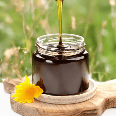 Miellat au Miel de Manuka de Nouvelle-Zélande, pot de Miel avec un Millat liquide très sombre qui coule