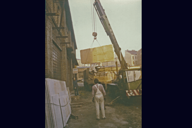 Ein Kroll-Autokran hebt die schweren Natursteinplatten vom LKW.