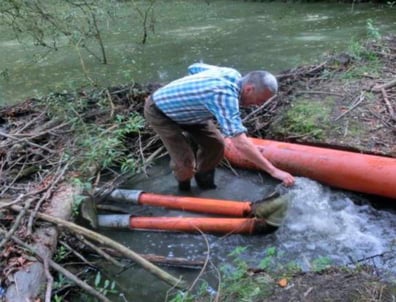 LBV-Aktiver beim Verlegen von Rohren durch einen Biberdamm