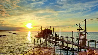 Meer, Sonnenuntergang und Fischerhütte