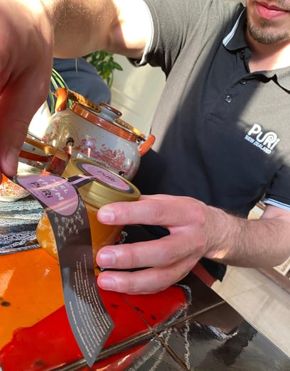 Photo d'Adrien de Puri New Zealand qui pose une étiquette pour la vente du Miel Rare et Pur de Thym de Nouvelle-Zélande