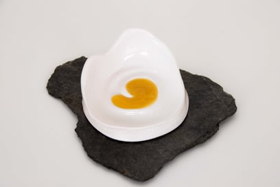 Magnifique photo d'un Miel de Manuka Gourmet de Nouvelle-Zélande posé sur un présentoir en céramique au dessus d'une ardoise esthétique