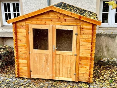 Weiße Holzhütte mit zwei Fenster, Zettel ins Fenster geklebt