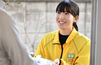 高齢者の自宅に弁当を配達して届ける宅配クック123の女性スタッフ