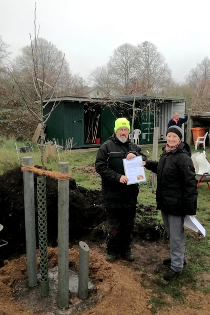Nach der Pflanzung: Übergabe der Spendenurkunde für den frisch gepflanzten Apfelbaum der Sorte "Gewürzluiken" von Frau Rosel Bührer vom Verein Alte Obstwiese Neumünster e.V. an den 1. Vorsitzenden der NABU-Gruppe Neumünster e. V. Björn Rickert.