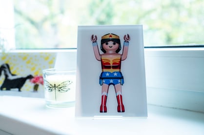 Katharina Wanha sitz in Wiese und lacht aus einem weißen Bilderrahmen