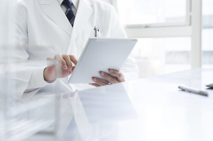 Person mit Kittel geht eine Checkliste durch im Rahmen unseres Prüfverfahrens