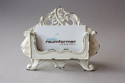 Romantische Visitenkartenhalter cremefarbig aus Metall, verspielt, schnörkelig, floral, stellenweise fehlt Farbe, damit der Shabby Stil unterstrichen wird