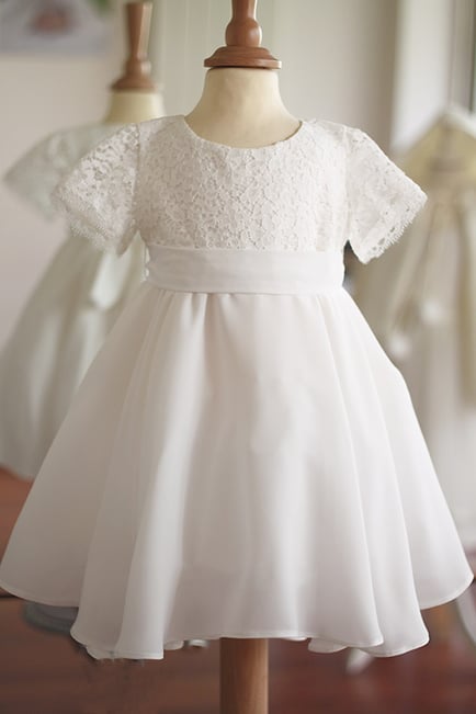 Robe bapteme bebe fille en crêpe fluide blanc cassé et dentelle. Modèle de robe de baptême Eglantine créé par Fil de Légende. Magasin vêtements baptême Paris, Neuilly-sur-Seine. Expédition en France et à l'international.