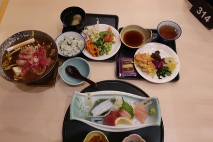 Ein Tablett mit edlen rohen Fleischstücken, Saucen sowie Salat und Reise als Beilage