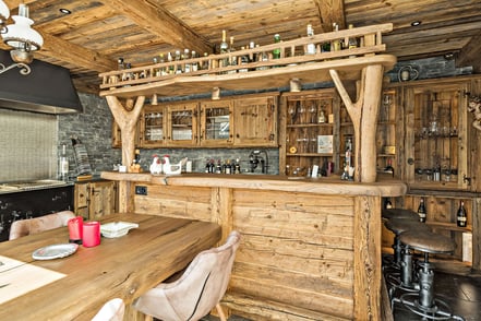 Die Bar mit integrierter großer Kühlvitrine, Kühlschrank und Geschirrspüler, alle mit Altholz verkleidet. 