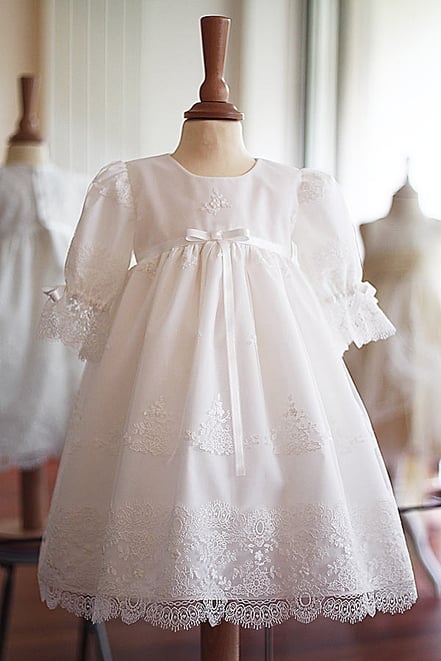 Robe baptême bébé fille courte en dentelle blanche. Fait-main dans l'atelier Fil de Légende à Neuilly-sur-Seine. Boutique baptême Paris, Ile de France. Envois dans la France entière
