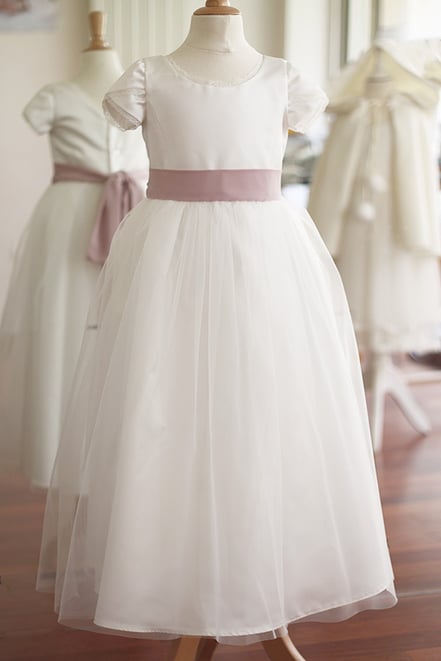 Robe longue cérémonie fille en satin blanc cassé et tulle avec ceinture en crêpe vieux rose. Modèle robe Charlotte créé par Fil de Légende. Magasin vêtements cérémonie enfants Paris, Neuilly-sur-Seine. Expéditions en France et à l'international.