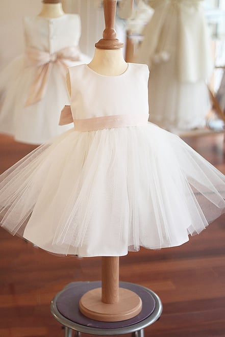 Robe cérémonie bébé fille en coton, tulle et ceinture rose poudrée. Robe baptême fille Anais, Fil de Legende. Magasin vêtements baptême Paris, Neuilly-sur-seine. Expédition en France et à l'international.