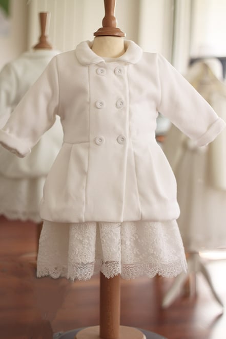 Manteau bapteme bebe automne hiver en lainage blanc cassé doublé polaire. Modède de manteau cérémonie enfant Albane par Fil de Légende. Magasin vêtements baptême bébé Paris, Neuilly-sur-Seine. Expéditions en France et à l'international.