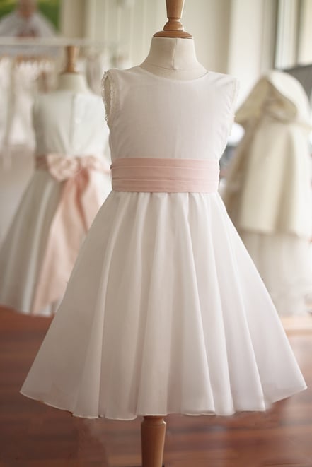 Robe cérémonie fille en mousseline de coton blanc cassé et ceinture taffetas rose poudré. Modèle robe cortège fille Juliette créée par Fil de Légende. Magasin vêtements enfants Paris, Neuilly-sur-Seine. expédition en France et à l'international.
