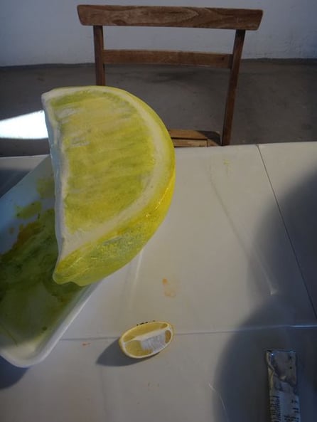 Reproducción de gajo de limón escala gigante (delante se ve el limón real) para el escaparate de una coctelería