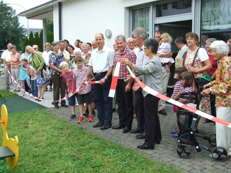 Markus Walliser (ref. Kirchenpflege), Jürg Epting (kath. Kirchenpflege), André Mathez (Baugenosschenschaft Sonnenberg) und Annemarie Burkard (Frauenverein Bubikon-Wolfhausen) durchschneiden gemeinsam das Band zum neuen Spielplatz