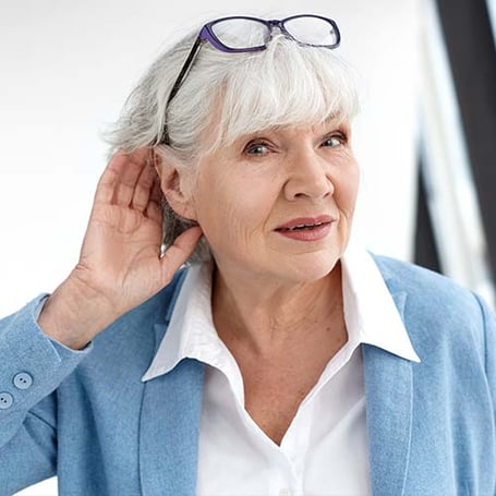 dame avec main sur l'oreille pour mieux entendre audition 44