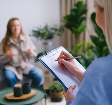 Eine Frau erklärt ihr Anliegen, während Julia das dokumentiert