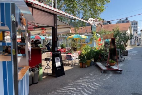 Gartenrestaurant mit bunten Sonnenschirmen und Kübelpflanzen im Zeughaushof Zürich