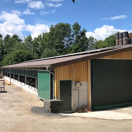 Außenansicht eines Warmstalls mit Auslauf