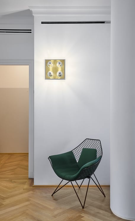 Una poltrona DU 43 di Gastone Rinaldi per Rima, 1953, in verde è una presenza d’effetto nell'interno dai toni soft. La lampada a parete è vintage.