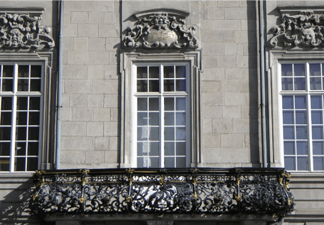 Barocke Hausfassade mit Sprossenfenstern und schmiedeeisernem Balkon 