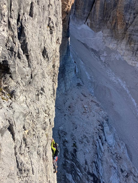 Kletterer mitten in der Felswand auf dem Weg zum Berggipfel