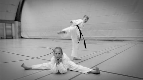 Karate-Kids: Beim Kindertraining zeigen zwei Schüler einen Spagat und einen Tritt in die Luft.