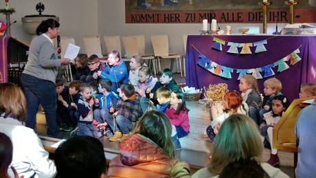 Franziska Seiser im Gespräch mit den 13 Erstkommunion Kindern vor dem Altar, März 2023.