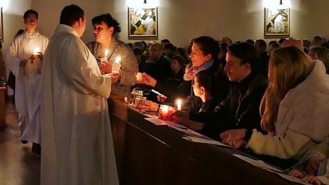Das Friedenslicht wird an die Messbesucher weitergegeben.
