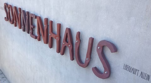 PD - 2012 - Entwurf Schriftzug SONNENHAUS (Fassadenaufschrift) - Buchstaben aus Keramik, hochgebrannt und unbehandelt (pro mente, TS Keramik, Linz), Untergrund: geschliffener Sichtbeton, Befestigung: Messingschrauben