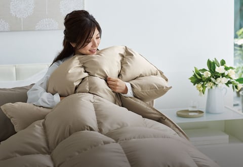 プレミアム羽毛ふとんの心地よさに、おふとんを抱きしめる女性