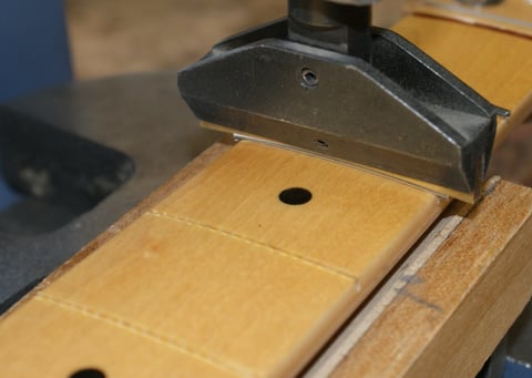 Nach der Überarbeitung und Vorbereitung werden die Edelstahlbünde vorgebogen und in die Bundschlitze gepresst.