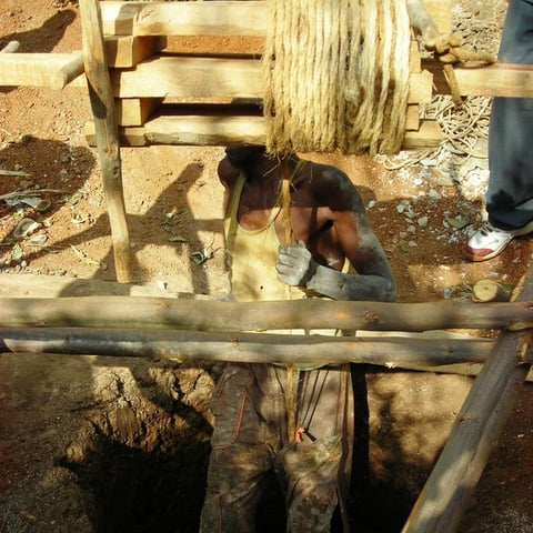 uomo che si cala nel pozzo per continuare lo scavo