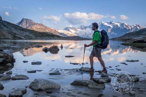 Wanderer überquert kristallklaren Bergsee