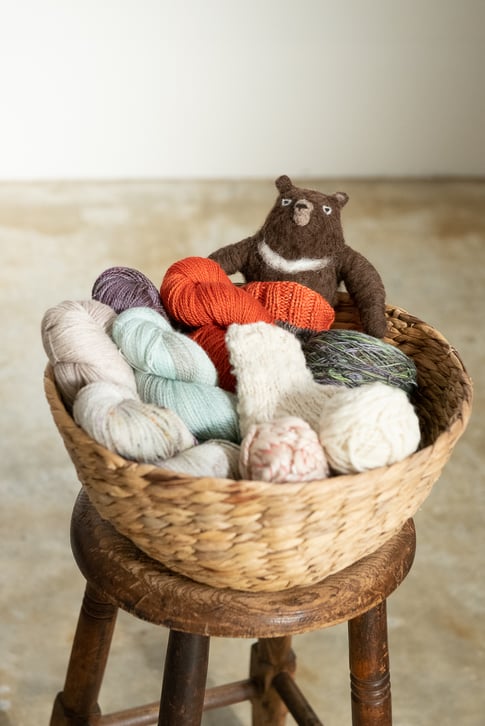 ▲緒方さんが染めた毛糸と著書『手のひらの動物・羊毛でつくる絶滅危惧種』(主婦の友社)よりツキノワグマ