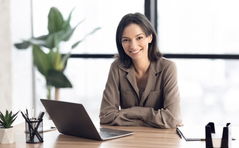 Freundliche junge Frau lächelnd vor der Kamera im Büro