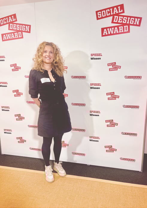 Stefanie Eichholtz von wordmate vor der Social Design Award-Pressewand bei der Preisverleihung – visuelles Beispiel für Kommunikationsarbeit und Community-Building im Mehrgenerationenhaus Heidelberg.