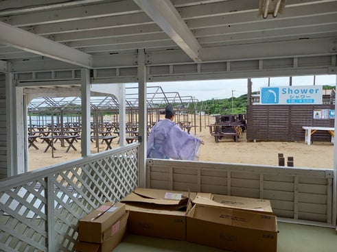 神主さんがお清めのお酒やお塩を海岸にまきます