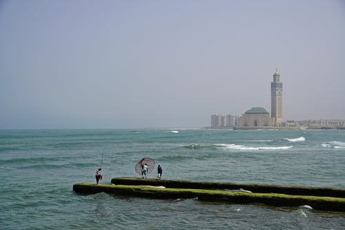 2023/04: Fischer werfen Ihre Netzte aus. Im Hintergrund die mächtige Hassan-II.-Moschee (MA)