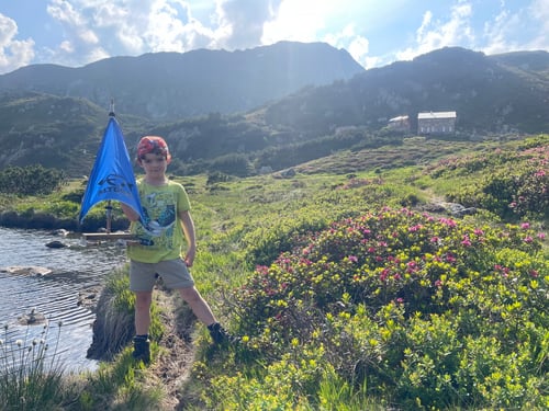 Luca mit dem kleinen Segelboot. Im Hintergrund die Suniggrathütte.