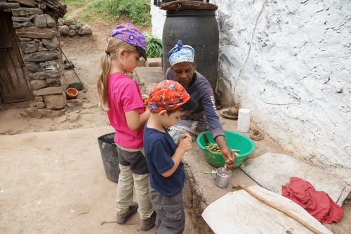 Emilia und Luca helfen beim Bohnen rüsten.
