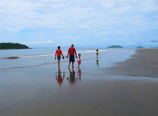 Strand-Spaziergang mit der Familie - neugierig schaut das kleine Mädchen zurück