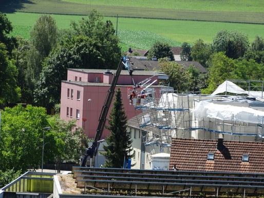 Mit einem Kran wird von der gesperrten Zinkereistrasse aus das vom Gewitter beschädigte Baugerüst repariert. (Bild: buebikernews)