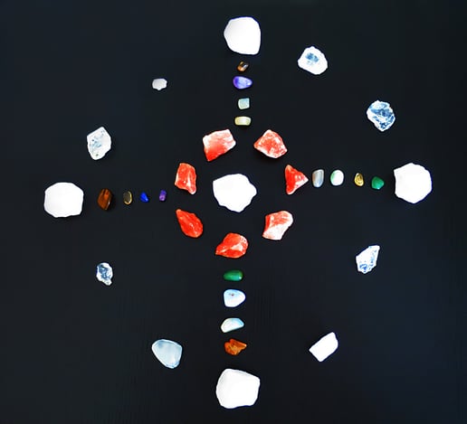 Auf schwarzem Untergrund sind verschiedene Steine nach der Regel des schamanischen Medizinrades angeordnet