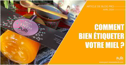 Photo d'un pot de Miel de Thym de 240g sur une table qui est en train de se faire poser une étiquette pour le vendre