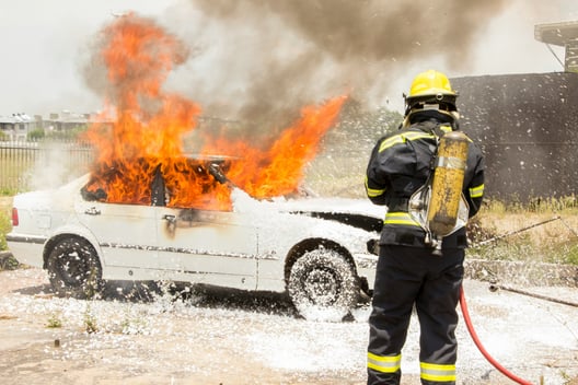 Photo d'un pompier américain qui éteint une voiture en feu
