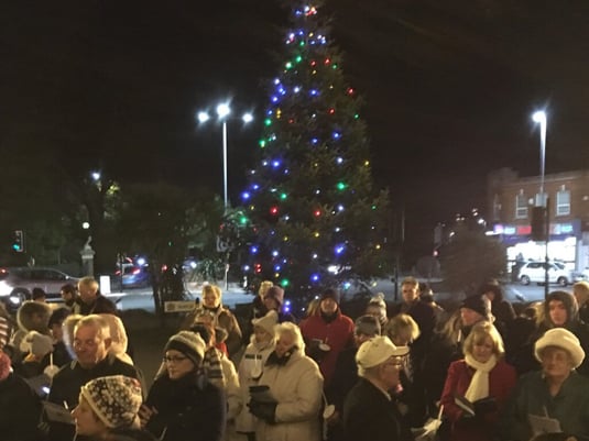 A group of carol singers around the Poole town hall Christmas tree.